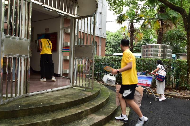 图为志愿者帮助新生搬运行李