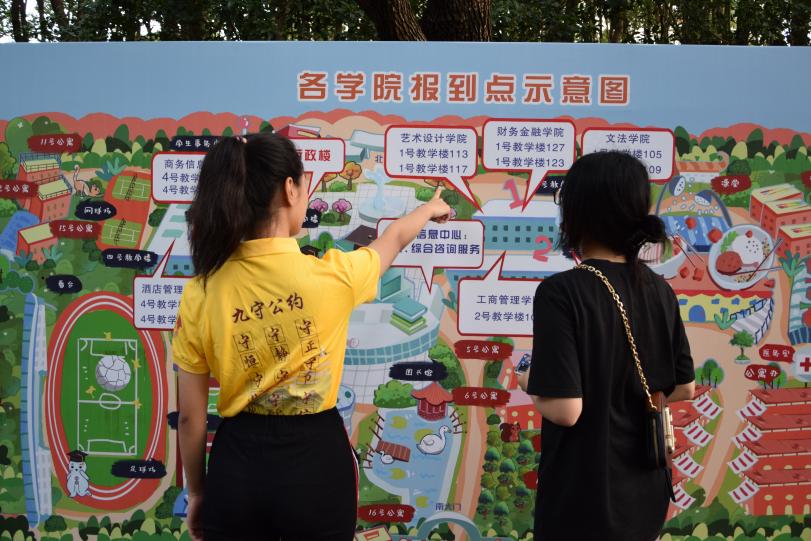图为志愿者为新生介绍校园示意图