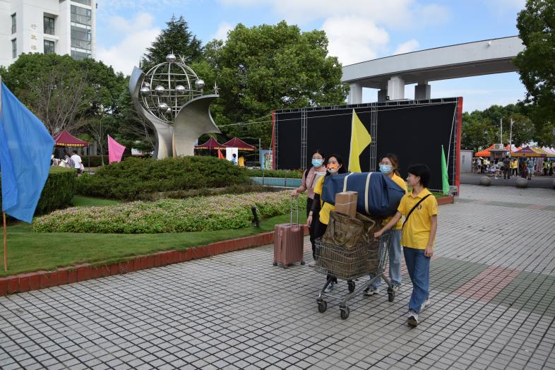 图为志愿者在校园门口迎接新生
