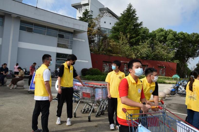 图为志愿者在校园门口迎接新生