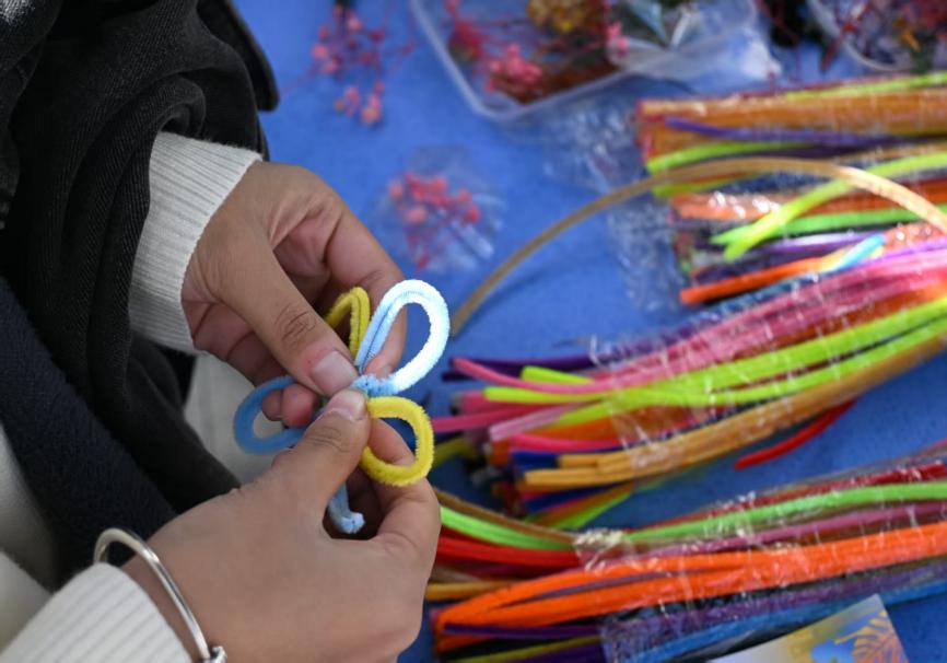 图为同学们在“扭花簪心”活动中制作簪花